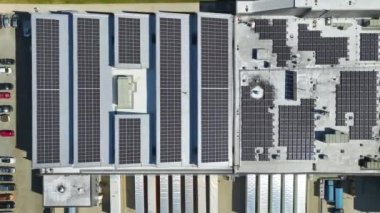 Sanayi binasının çatısına yeşil ekolojik elektrik üretmek için monte edilen mavi fotovoltaik güneş panellerinin hava görüntüsü. Sürdürülebilir enerji konsepti üretimi.