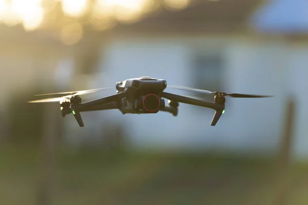 stock image Drone aircraft with blurred fast rotating propellers and video camera flying in air.