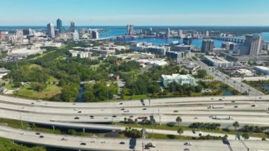Jacksonville şehrinin hava manzarası. Yüksek ofis binaları ve hızlı araba ve kamyonlarla Amerikan otoyolu kavşağı. ABD ulaşım altyapısının üstünden görüntüle.