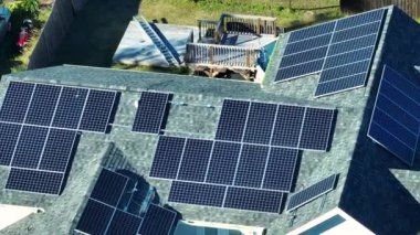 Temiz ekolojik elektrik enerjisi üretmek için mavi güneş fotovoltaik panelleri olan tipik Amerikan binasının çatısı. Emeklilik geliri kavramı için yenilenebilir elektriğe yatırım.