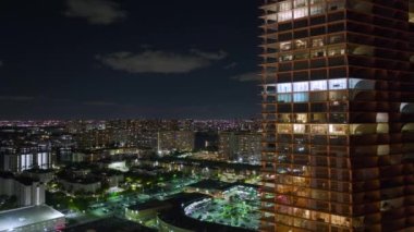 Florida, ABD 'deki Sunny Isles Beach City' de gece vakti aydınlık bir konut binasının yüksek açılı görüntüsü. Modern Amerikan kentsel bölgesinde konut geliştirme.