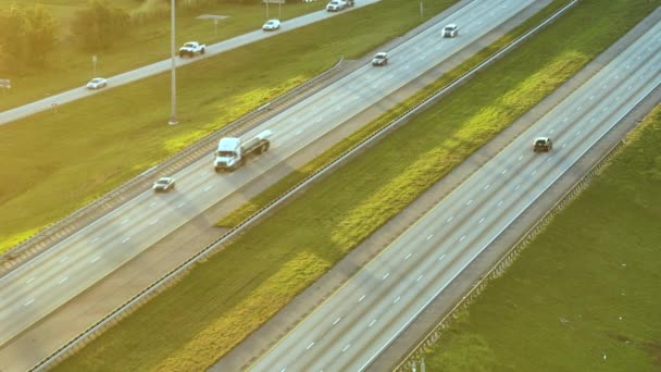 日没時に多くの運転車やトラックと広い混雑したアメリカの高速道路の高い角度ビュー 国際輸送システムの概念 — ストック動画