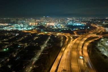 Aerial view of american highway junction at night with fast driving vehicles in Tampa, Florida. View from above of USA transportation infrastructure.