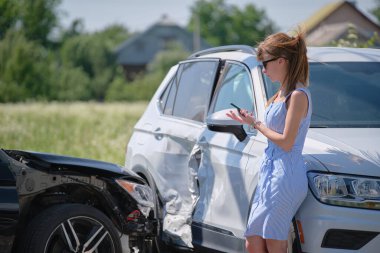 Stressed woman driver talking on mobile phone on street side calling for emergency service after car accident. Road safety and insurance concept. clipart