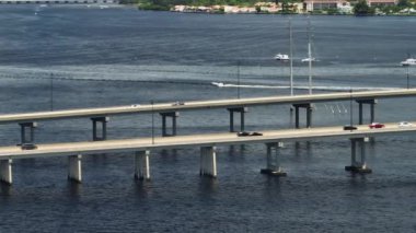 Aerial view of Barron Collier Bridge and Gilchrist Bridge in Florida with moving traffic. Transportation infrastructure in Charlotte County connecting Punta Gorda and Port Charlotte over Peace River.