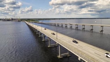 Aerial view of Barron Collier Bridge and Gilchrist Bridge in Florida with moving traffic. Transportation infrastructure in Charlotte County connecting Punta Gorda and Port Charlotte over Peace River.