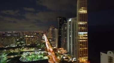 Florida, ABD 'deki Sunny Isles Beach şehrinin şehir merkezindeki hava manzarası. Günümüz Amerika 'sında yoğun trafik ve yüksek gökdelen binalarıyla aydınlık cadde.