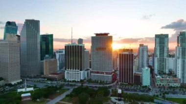 Gün batımında ABD 'nin Florida kentindeki Miami Brickell' in şehir merkezindeki ofis manzarası. Modern Amerikan megapolis 'inde yüksek ticari gökdelen binaları ve şehir trafiği.
