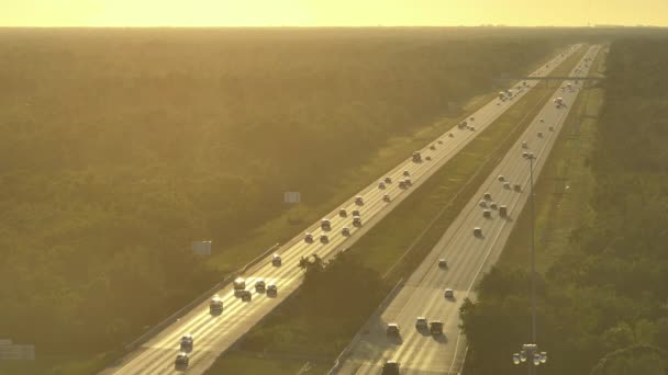 日の出に速い移動トラフィックを持つ忙しいアメリカの高速道路 長距離移動のための迅速な輸送のための州間輸送システム — ストック動画