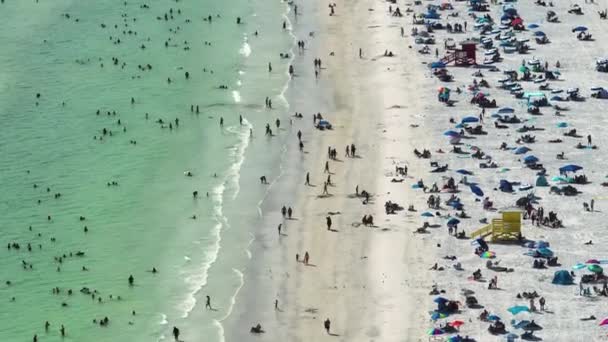 サラソータ 米国の混雑したシエスタキービーチの高角度ビュー 多くの人が海水浴や暖かいフロリダの太陽の下でリラックスした休暇を楽しんでいます — ストック動画