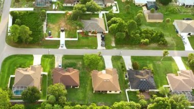 Florida 'nın sakin yerleşim bölgesinde yeşil palmiye ağaçları arasında özel evleri olan küçük bir Amerikan banliyö manzarası..