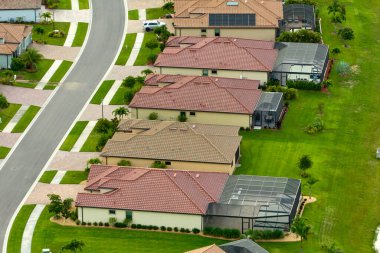 Florida 'daki kapalı yaşam kulübünde böcek koruması için metal çerçeveli sivrisinek ağıyla kaplı havuzları olan pahalı modern evlerin havadan görünüşü..