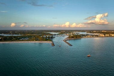 Venedik, Florida yakınlarındaki deniz kıyısının gün batımında deniz dalgaları üzerinde yüzen beyaz yatlarla görüntüsü. Nokomis sahilindeki Kuzey ve Güney Jetty. Okyanus yüzeyinde motorlu tekne tatili.