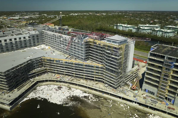 Aerial view of ruined by hurricane Ian construction crane on high apartment building site in Port Charlotte, USA.