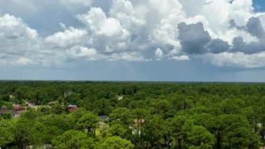 Dark stormy clouds forming on gloomy sky before heavy rainfall over suburban town area.