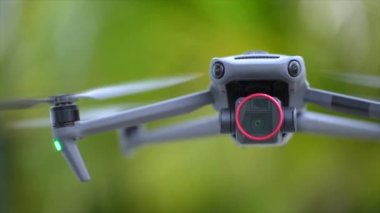 Drone quadcopter with digital camera and fast rotating propellers flying taking video and pictures.