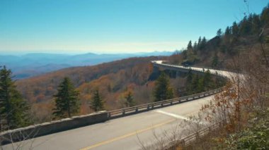 Blowing Rock, Blue Ridge Parkway, North Carolina, ABD yakınlarındaki Linn Cove Viaduct ile dağ sonbaharı manzarası. Sonbahar ormanları arasında manzaralı yolda araba sürmek.
