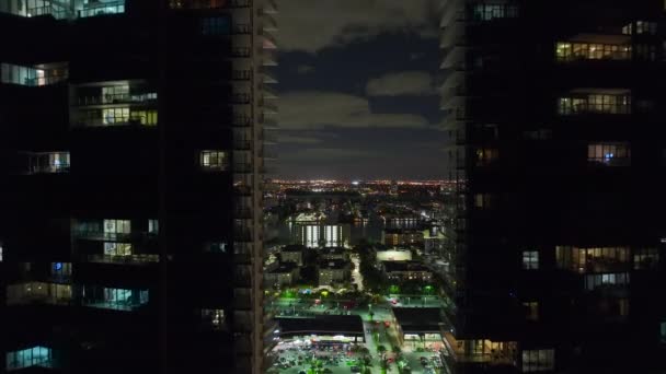 アメリカ合衆国フロリダ州のサニー アイルズ ビーチ市の中心街の夜景 現代のアメリカのメガポリスで明るく照らされた高層ビルの建物とスカイライン — ストック動画