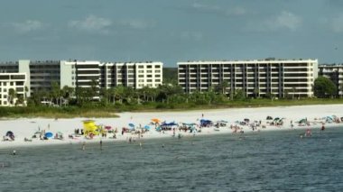 Siesta Key plajının yukarısından Sarasota, ABD 'de turistlerle dolu beyaz kumların görüntüsü. Birçok insan tatillerini Meksika körfezinde yüzerek ve sıcak Florida güneşinde dinlenerek geçiriyor..