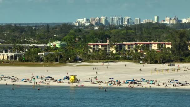 アメリカのサラソータにあるシエスタキー砂浜の空中風景 多くの観光客は 暖かいメキシコ湾の水と暑いフロリダの太陽の下で日光浴で夏休みの時間を楽しむ — ストック動画
