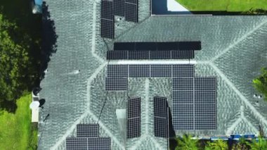 Temiz ekolojik elektrik enerjisi üretmek için mavi güneş fotovoltaik panelleri olan normal Amerikan ev çatısı. Sıfır emisyon kavramı ile yenilenebilir elektrik.