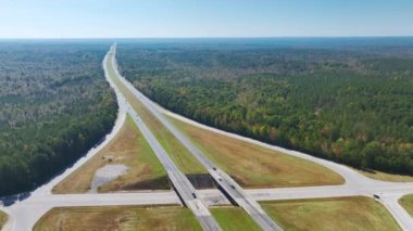 Elevated view of freeway exit junction over road lanes with fast moving traffic cars and trucks. Interstate transportation infrastructure in USA.