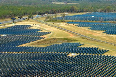 Temiz elektrik enerjisi üretmek için birçok sıra güneş fotovoltaik paneli bulunan sürdürülebilir büyük elektrik santralinin havadan görünüşü. Sıfır emisyon kavramı ile yenilenebilir elektrik.