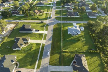 Küçük bir kasabada sokak trafiğinin hava görüntüsü. Florida 'da sakin yerleşim bölgesinde yeşil palmiye ağaçları arasında özel evleri olan Amerikan banliyö manzarası.