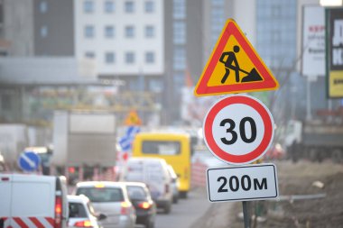 Yol çalışmaları trafik işaretlerini uyardı. Şehir caddesinde inşaat çalışması ve yavaş hareket eden arabalar..