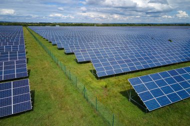 Temiz elektrik enerjisi üretmek için sıra sıra güneş fotovoltaik panelleri olan sürdürülebilir büyük elektrik santralinin havadan görünüşü. Sıfır emisyonlu yenilenebilir elektrik kavramı.
