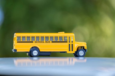Açık havada Amerikan sarı okul otobüsünün küçük bir modeli. ABD 'de eğitim güvenliği kavramı.