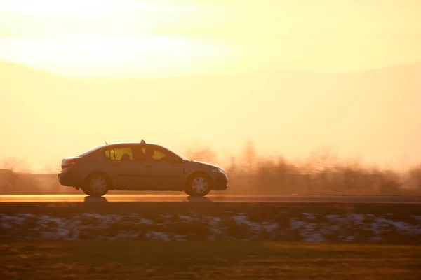 stock image Car driving fast on intercity road at sunset. Highway traffic in evening.