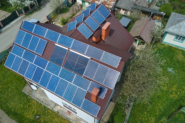 Residential house with rooftop covered with solar photovoltaic panels for producing of clean ecological electrical energy in suburban rural area. Concept of autonomous home.