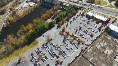 Bir alışveriş merkezinin önündeki otoparkta park edilmiş birçok arabanın üst görüntüsü. Tüketim ve piyasa ekonomisi kavramı.