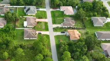 Florida 'nın sakin yerleşim bölgesinde yeşil palmiye ağaçları arasında özel evleri olan küçük bir Amerikan banliyö manzarası..