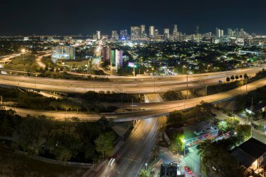 Miami, Florida 'da gece Amerikan otoyolu kavşağında hızlı giden araba ve kamyonlarla hava görüntüsü. ABD ulaşım altyapısının üstünden görüntüle.