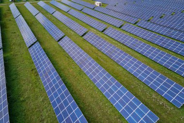 Temiz elektrik enerjisi üretmek için sıra sıra güneş fotovoltaik panelleri olan sürdürülebilir büyük elektrik santralinin havadan görünüşü. Sıfır emisyonlu yenilenebilir elektrik kavramı.