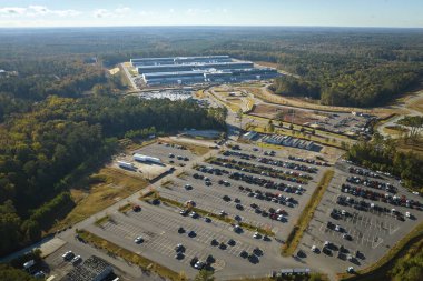 Birçok ortak araba endüstriyel fabrika binasının önündeki büyük otoparka park etti. Üretim ve küresel sanayi kavramı.