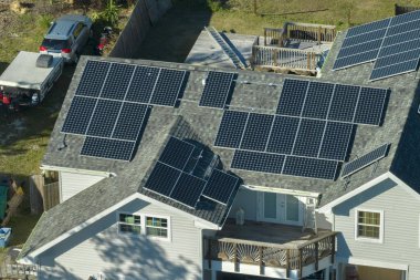 Banliyö bölgesinde temiz ekolojik elektrik enerjisi üretmek için çatısı güneş fotovoltaik panellerle kaplı ABD 'deki bir ev. Özerk konut kavramı.