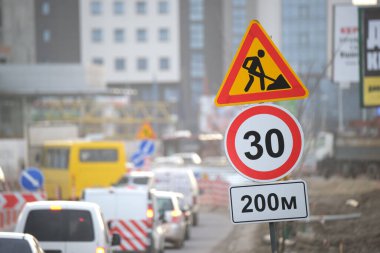 Yol çalışmaları trafik işaretlerini uyardı. Şehir caddesinde inşaat çalışması ve yavaş hareket eden arabalar..