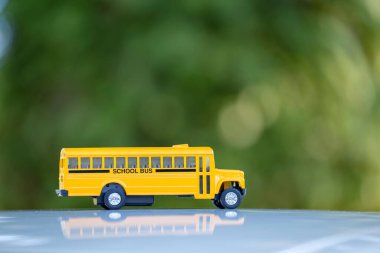 Small model of american yellow school bus as symbol of education in the USA.