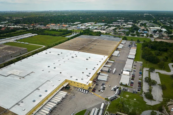 stock image Large commercial distribution storehouse with many semitrucks unloading and uploading retail products for international shipment. Global market economy concept.