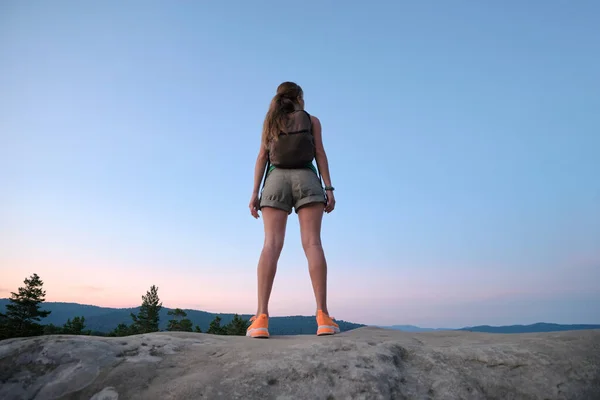 stock image Young woman hiker standing alone on mountain footpath enjoying view of evening nature on wilderness trail. Active way of life concept.