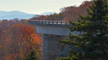 Blowing Rock, Blue Ridge Parkway, North Carolina, ABD yakınlarındaki Linn Cove Viaduct ile dağ sonbaharı manzarası. Sonbahar ormanları arasında manzaralı yolda araba sürmek.
