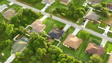 Aerial landscape view of suburban private houses between green palm trees in Florida quiet rural area.