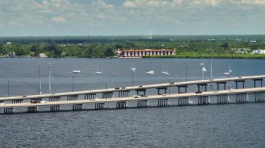 Aerial view of Barron Collier Bridge and Gilchrist Bridge in Florida with moving traffic. Transportation infrastructure in Charlotte County connecting Punta Gorda and Port Charlotte over Peace River.