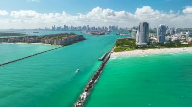 Güney Sahili yakınlarındaki Miami limanı ana kanalından büyük konteynır gemisinin hava görüntüsü. Sahildeki lüks oteller ve apartmanlar ve şehir merkezindeki yüksek gökdelenler.