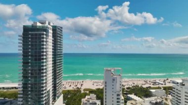 Sıcak Florida güneşinde dinlenen turistlerle birlikte güney sahilinin kumlu yüzeyi. Yüksek lüks otelleri ve apartmanları olan Miami Beach City. Güney Amerika 'da turizm altyapısı.