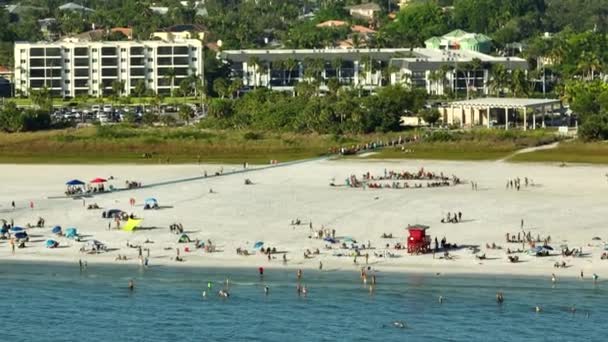サラソータ 米国のシエスタキー砂浜と空中の夕景 多くの観光客は 暖かいメキシコ湾の水と暑いフロリダの太陽の下で日光浴で夏休みの時間を楽しむ — ストック動画