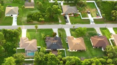Aerial landscape view of suburban private houses between green palm trees in Florida quiet rural area.